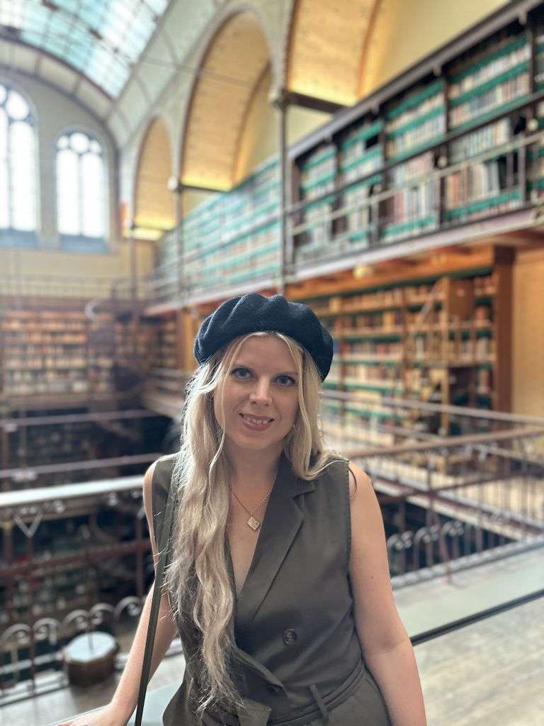 Natalie Forslind omringad av böcker i Amsterdams riksmuseums bibliotek. 