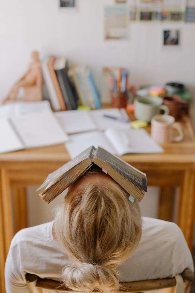 Writer hiding under a book.